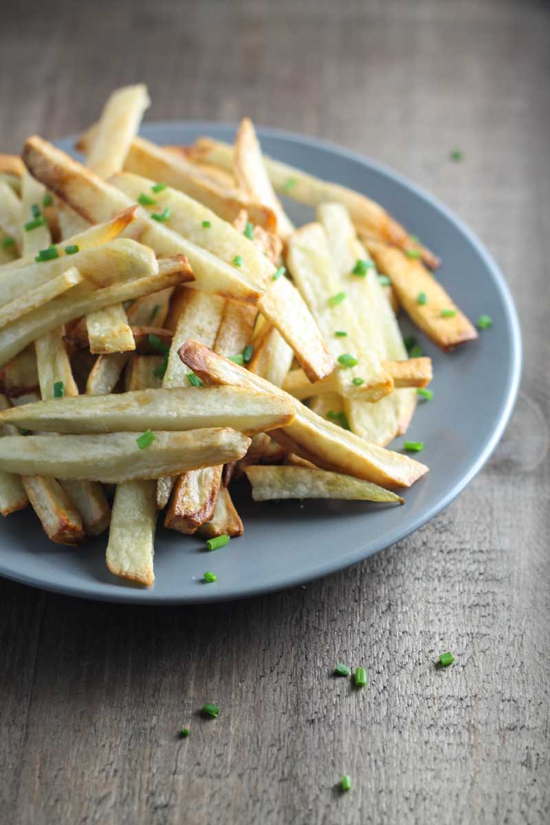 A plate of homemade "garlic" fries topped with snipped chives.