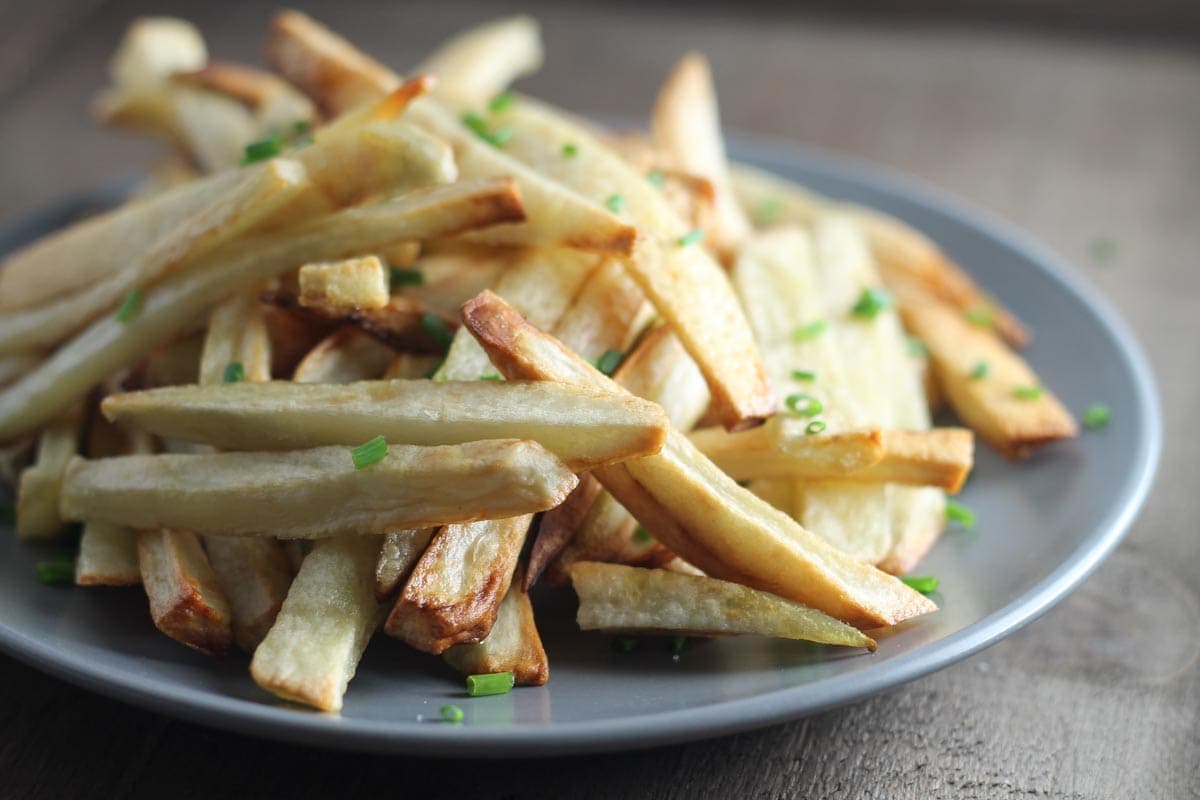 A plate of homemade fries topped with snipped chives