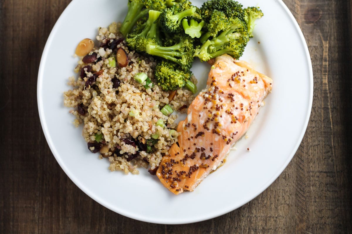 A plate of salmon with quinoa pilaf and roasted broccoli