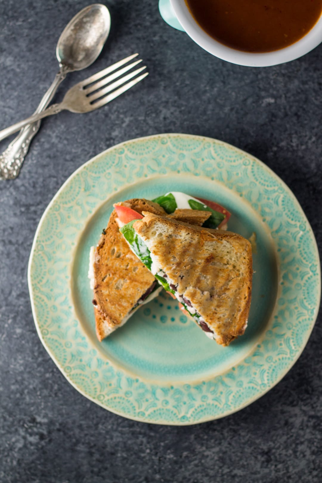 Overhead shot of low FODMAP Mediterranean grilled cheese on a patterned teal plate. 