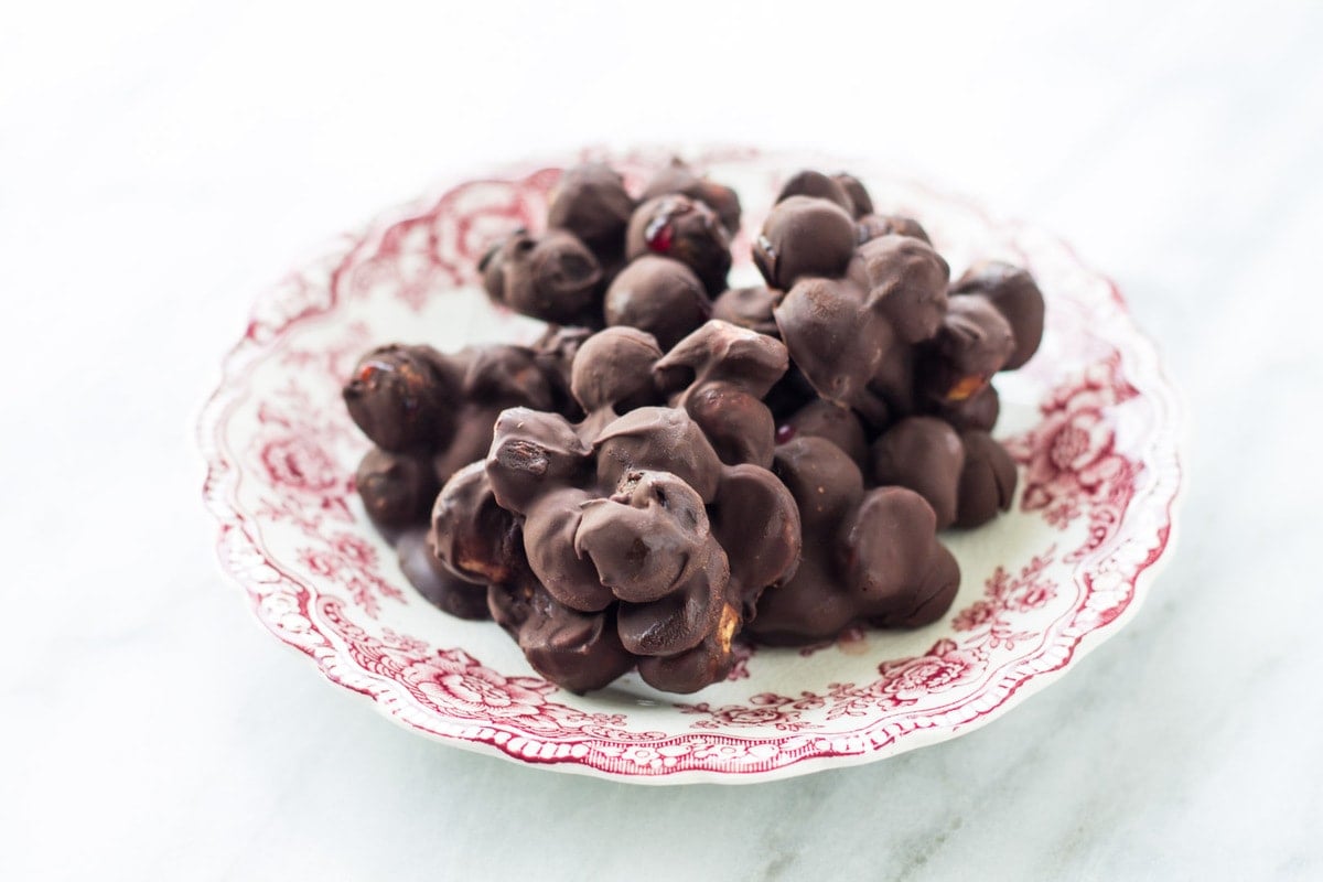 Antique plate filled with low FODMAP dark chocolate blueberry mac nut bites