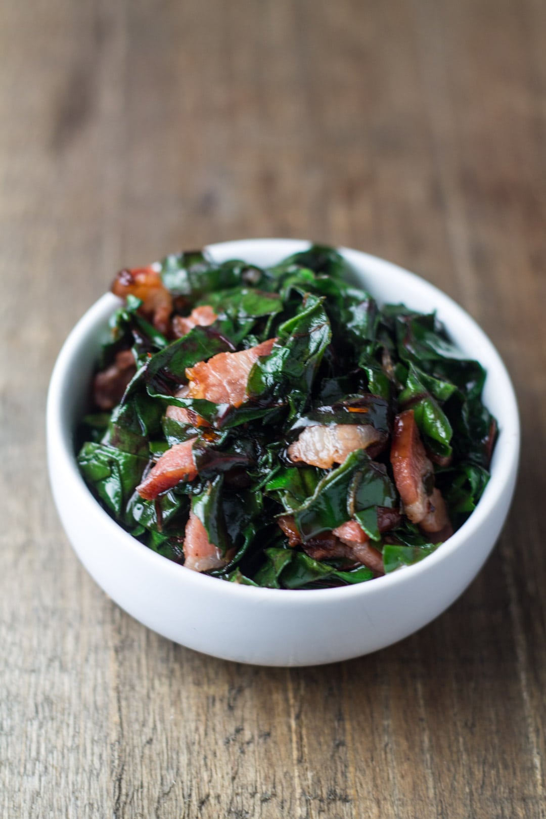 A small bowl of Swiss chard and bacon crumbles.