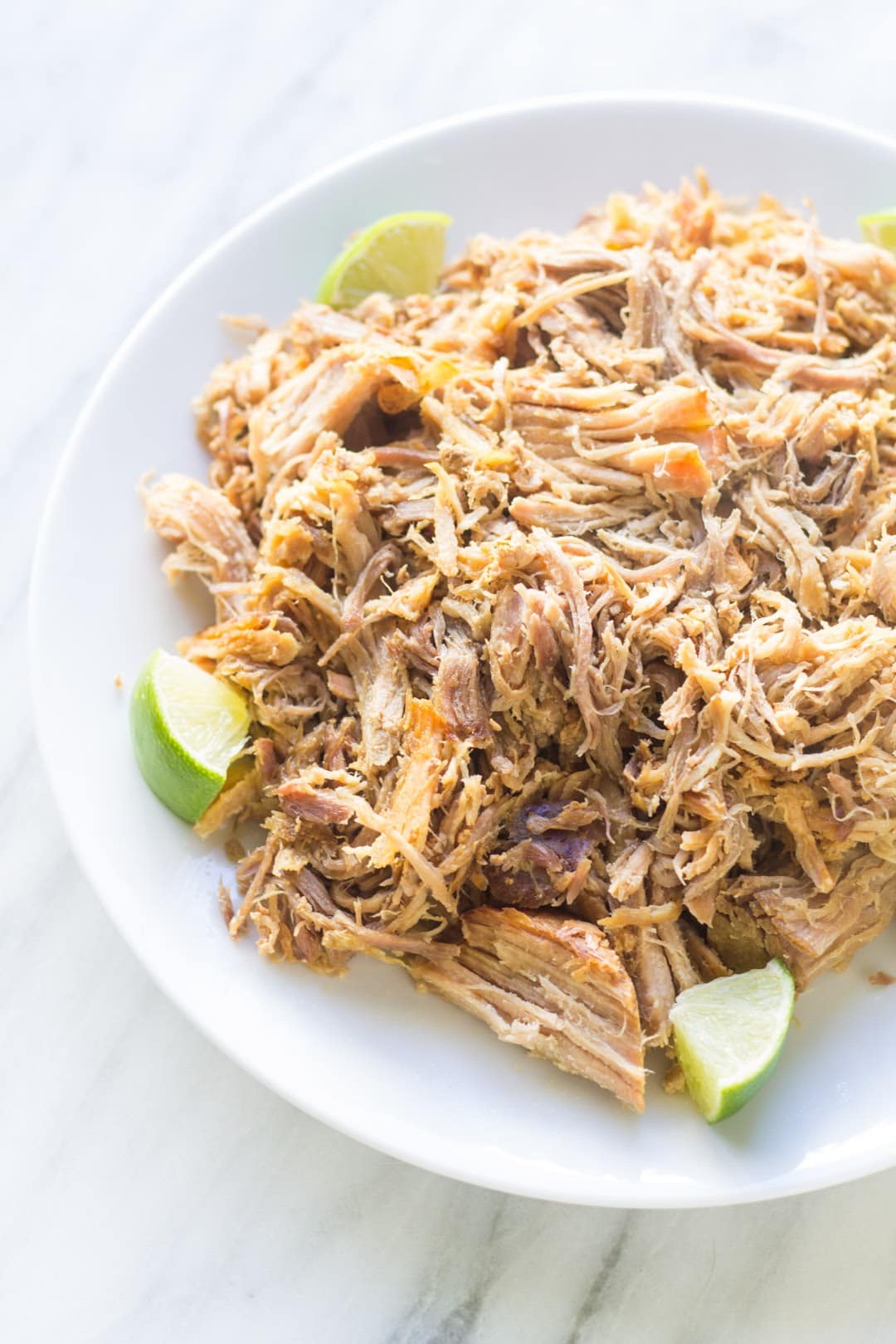 Close up of low FODMAP carnitas with lime wedges