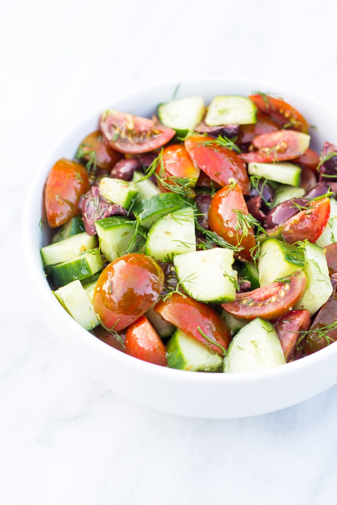 Bowl of quartered cherry tomatoes, quartered cucumber, fresh dill, and a light dressing. 