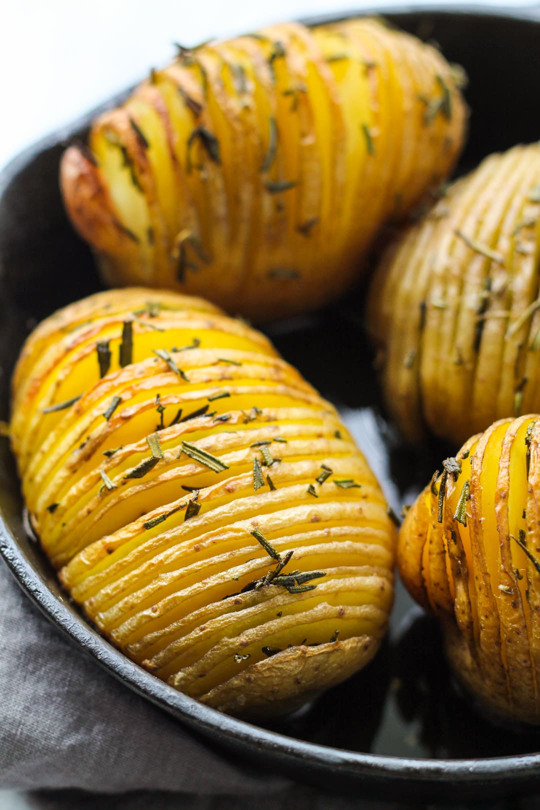 Close up of baked hasselback potatoes in a skillet