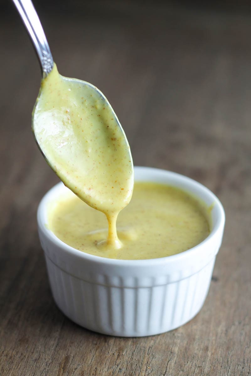Spoon dipped in low FODMAP creamy maple mustard