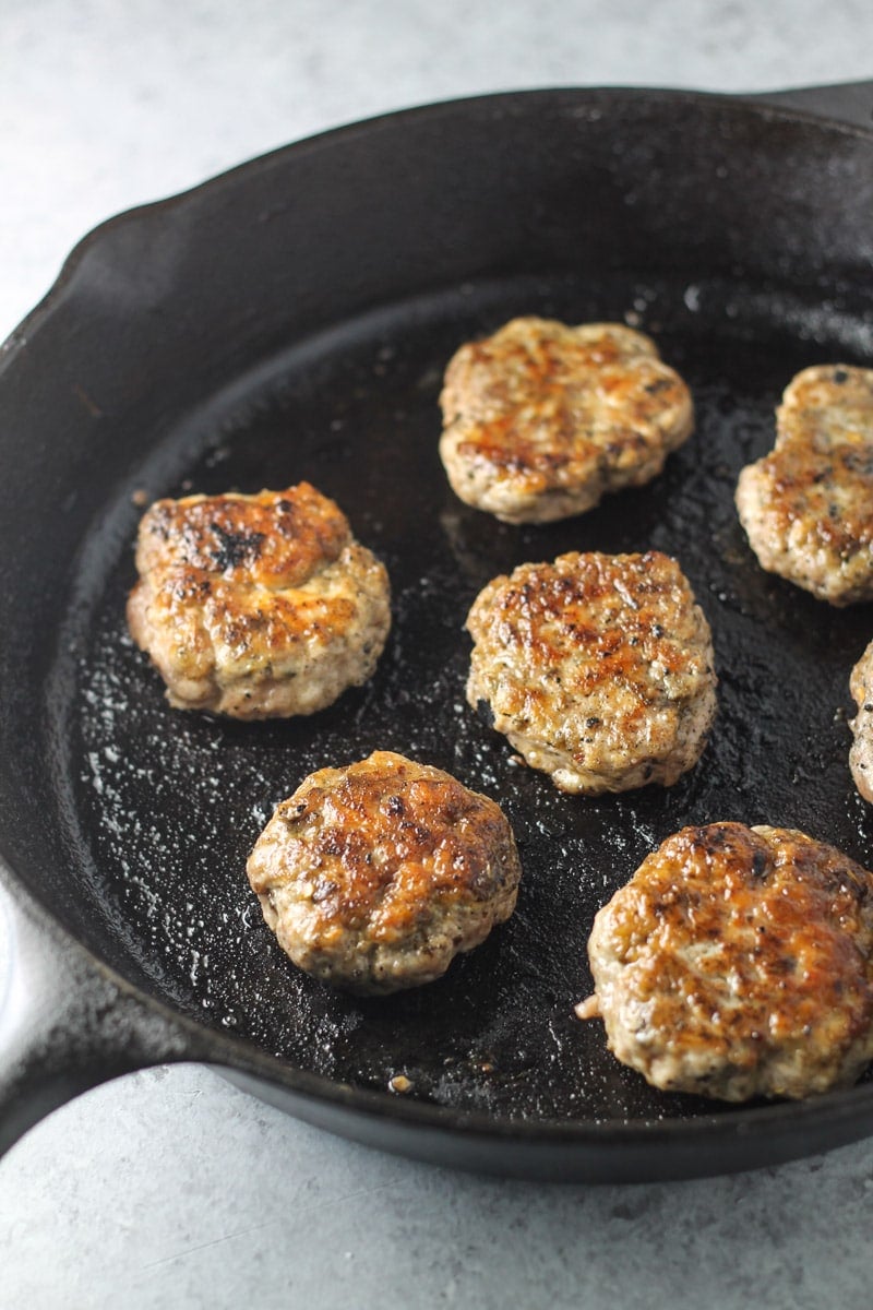 Low FODMAP breakfast sausage patties cooked in a cast-iron skillet.