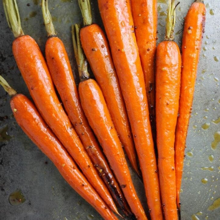 Roasted green top carrots on sheet pan.