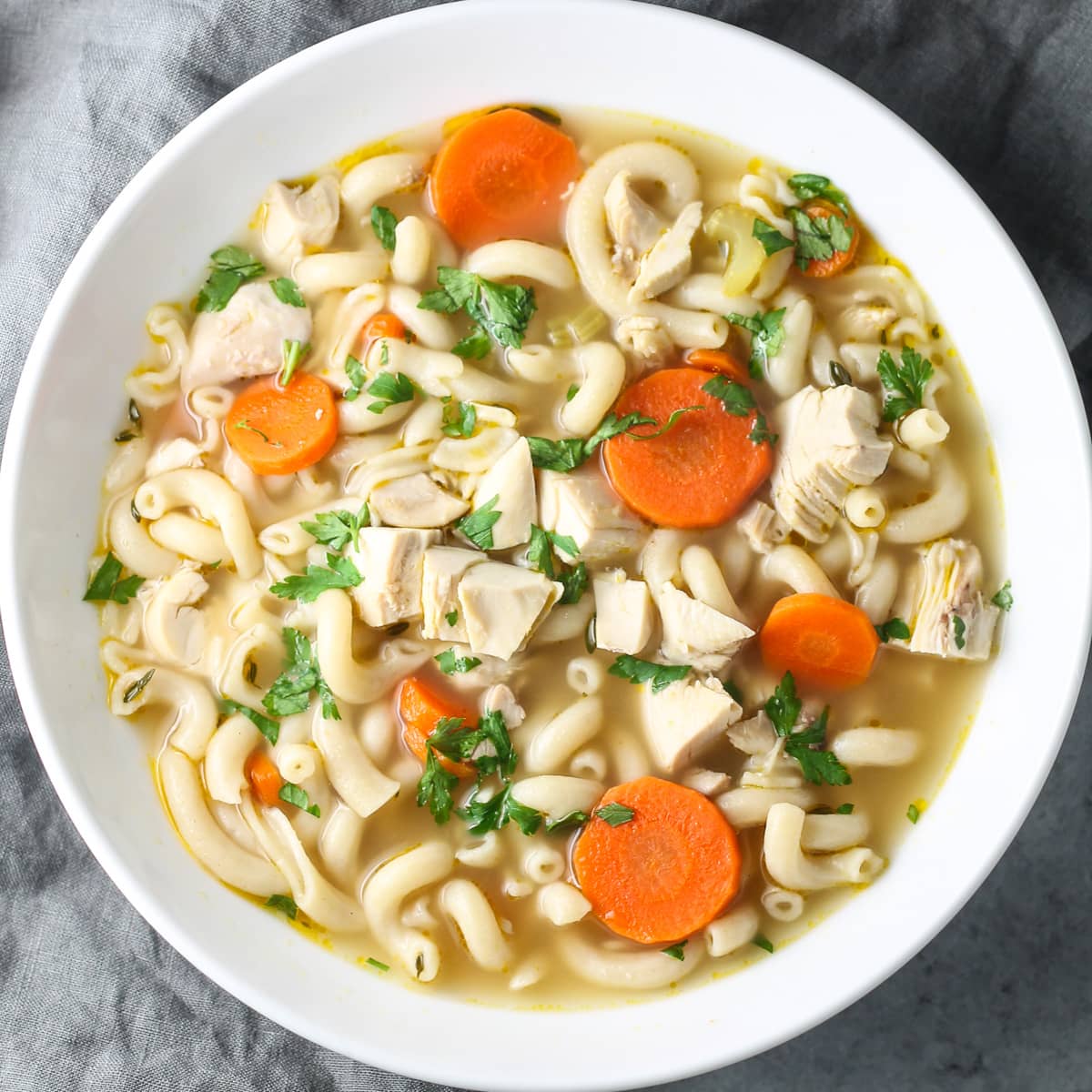 A large bowl of homemade low FODMAP chicken noodle soup.