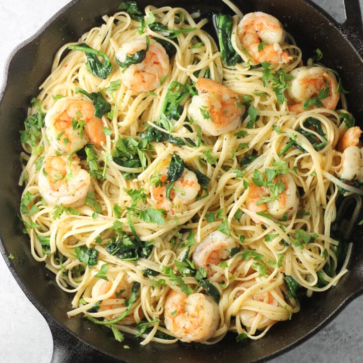 Cast-iron skillet filled with buttered pasta and shrimp