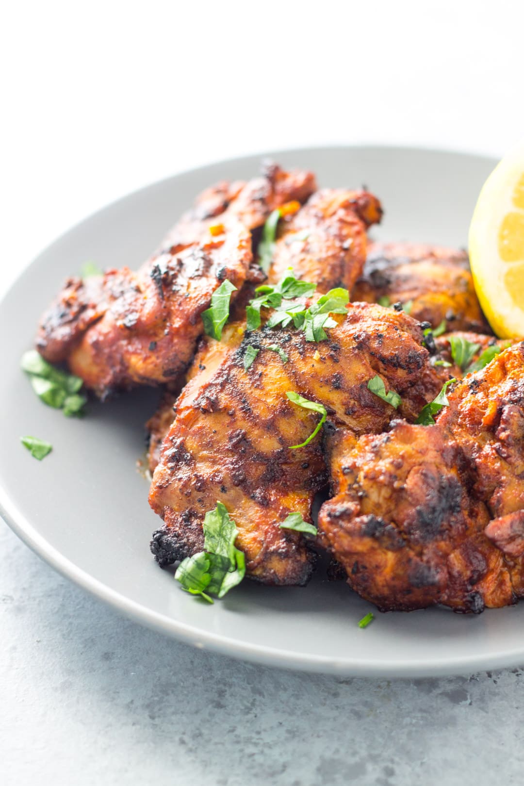 Grilled peri peri chicken thighs topped with chopped fresh cilantro.