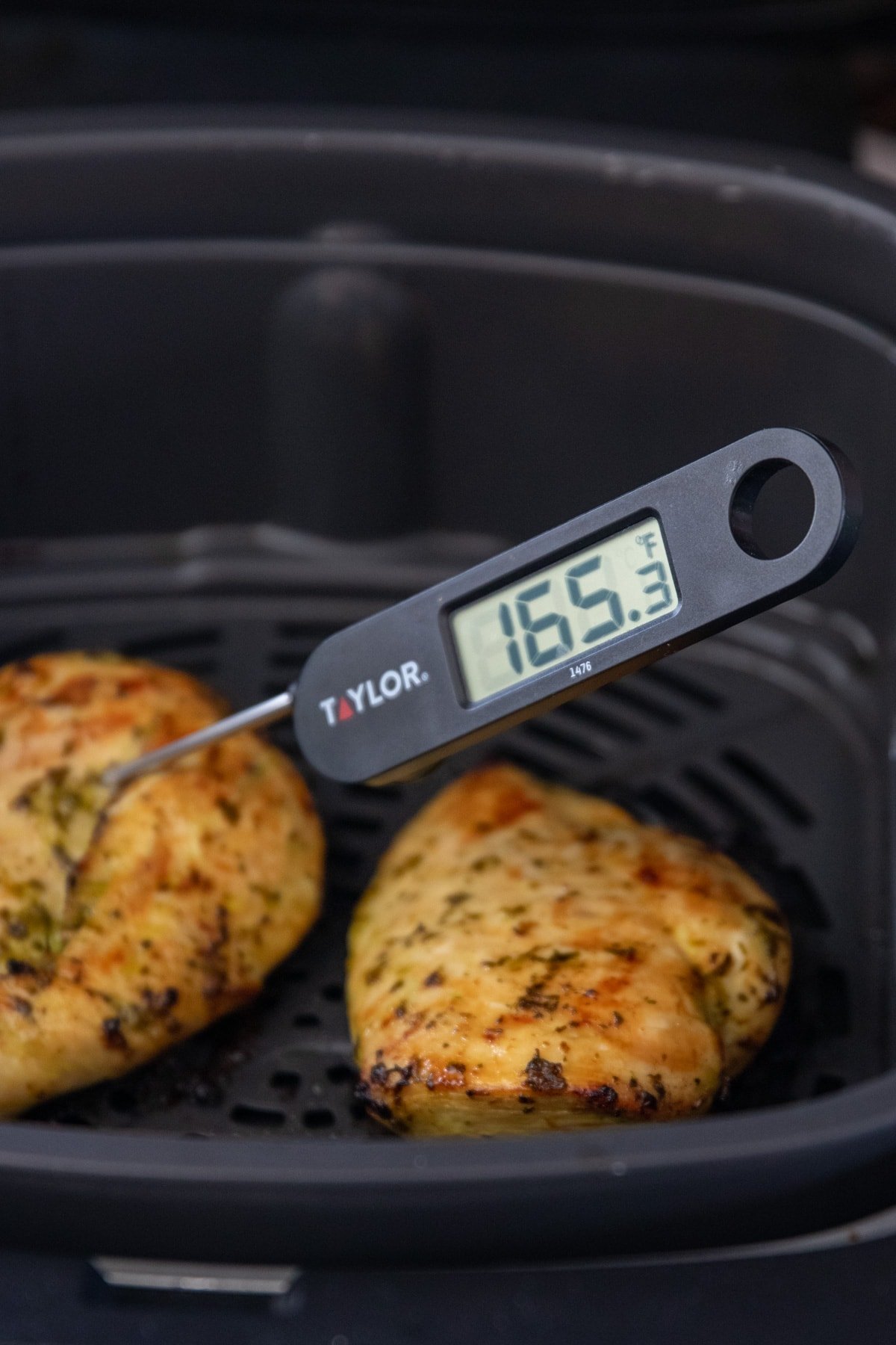 Food thermometer in cooked chicken reads 165F