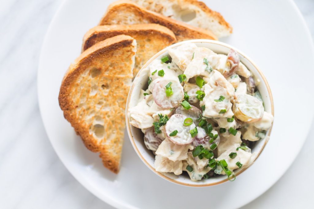 Overhead centered shot of low FODMAP chicken salad and grapes with toast