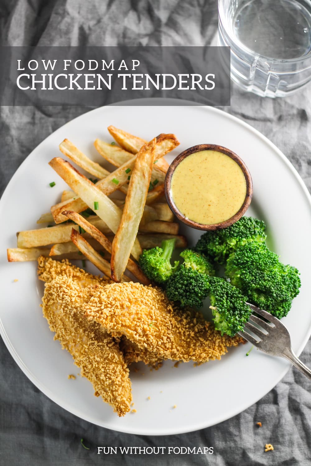 A plate filled with crispy chicken tenders, steamed broccoli, baked fries, and creamy maple mustard. A text overlay reads "Low FODAMP Chicken Tenders."