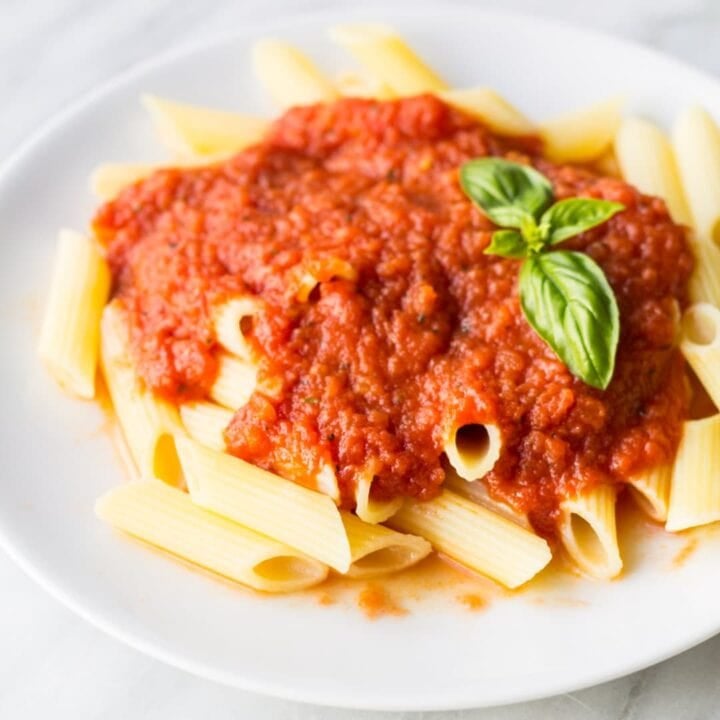A plate of gluten-free pasta topped with tomato sauce.
