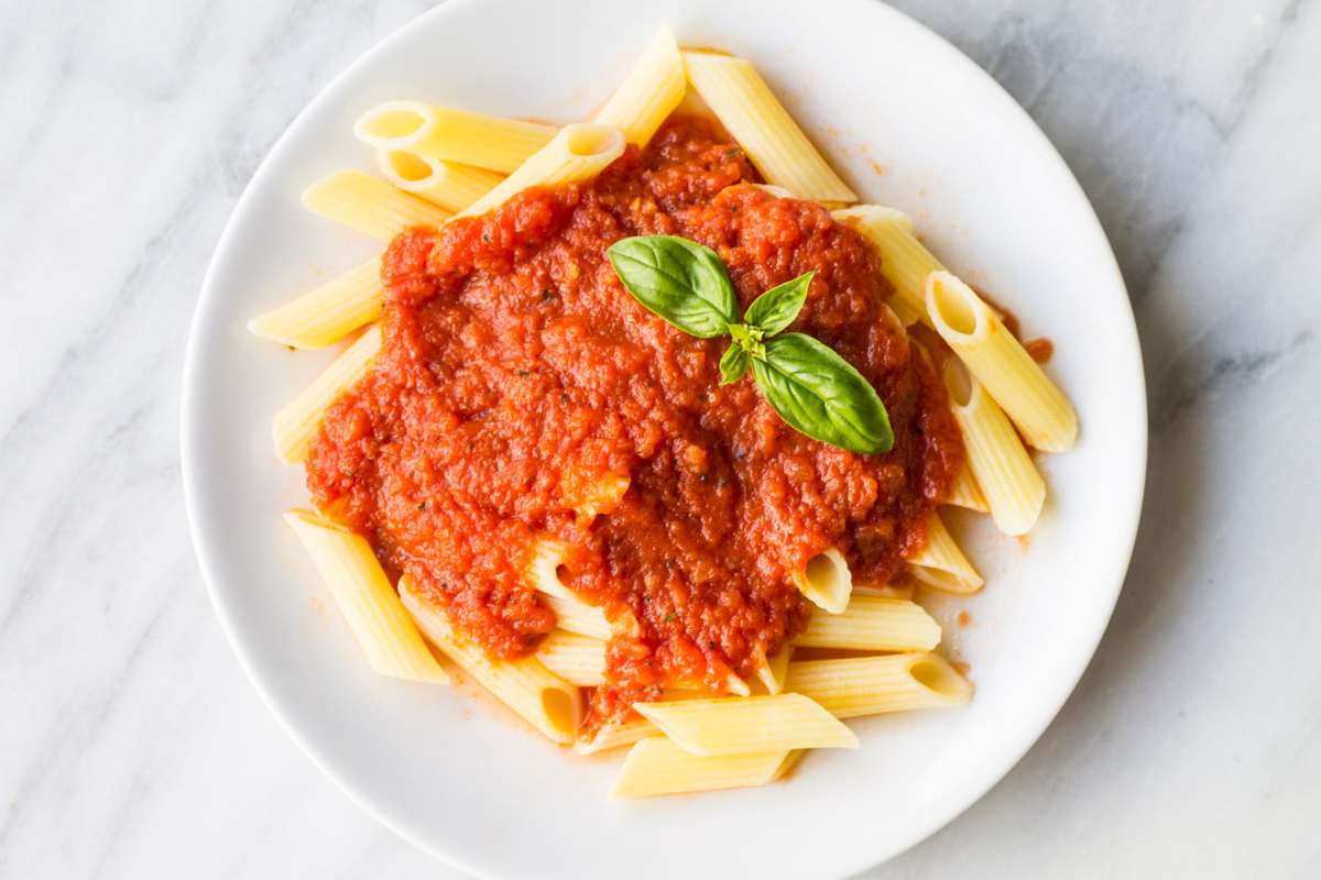 Looking down at a plate of pasta topped with homemade tomato sauce. 