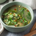 Bowl of tom yum soup with wooden spoons