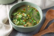 Bowl of tom yum soup with wooden spoons