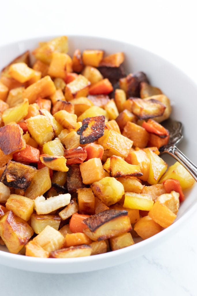 A white bowl filled with low FODMAP roasted root veggies