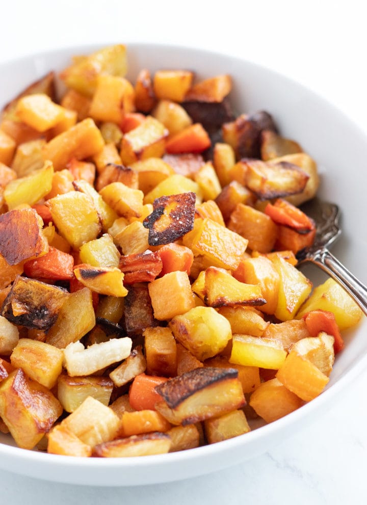 A white bowl filled with low FODMAP roasted root veggies