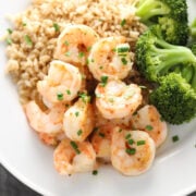 Maple-dijon shrimp on a plate with steamed broccoli and brown rice