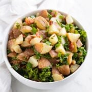 A bowl filled with warm potato salad with kale