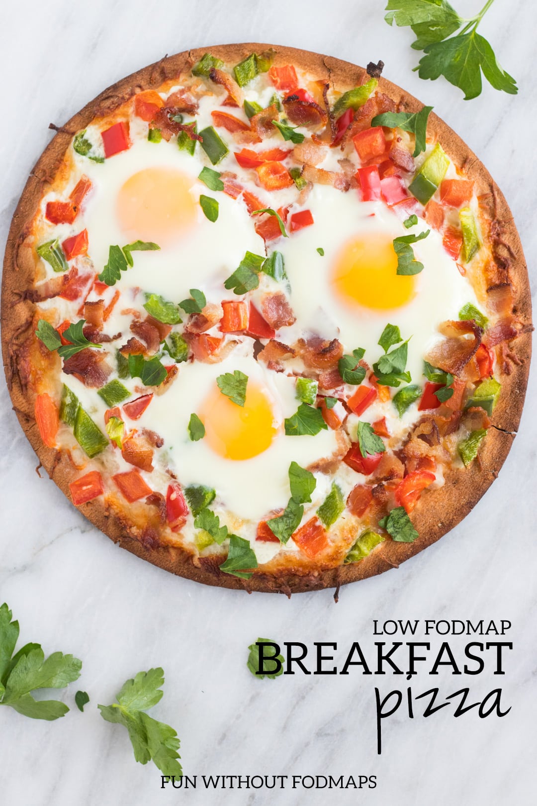 An overhead shot of a low FODMAP breakfast pizza on a white marble slab. Black text reads "low FODMAP breakfast pizza" in the bottom right corner.