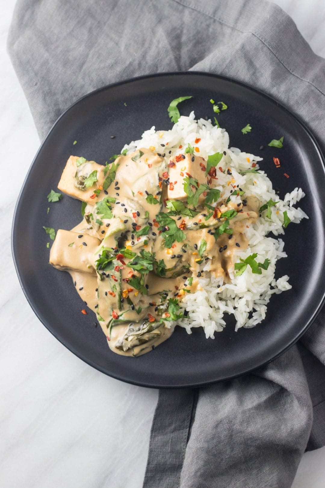 Tofu tossed in a creamy peanut butter and coconut sauce. It's served over white rice and garnished with red pepper flakes and chopped cilantro.
