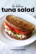A sandwich sits on a small white plate. In the white space above, black text reads "Low FODMAP Tuna Salad."