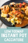 A scoop of low FODMAP Instant Pot Chicken Cacciatore served over creamy polenta and topped with basil chiffonade. It is served on black short rimmed plate with a tan cloth napkin underneath.