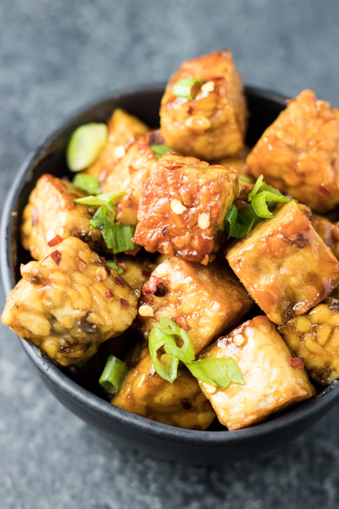 Browned tempeh tossed in a maple-soy glaze and topped with sliced green onions and red pepper flakes.