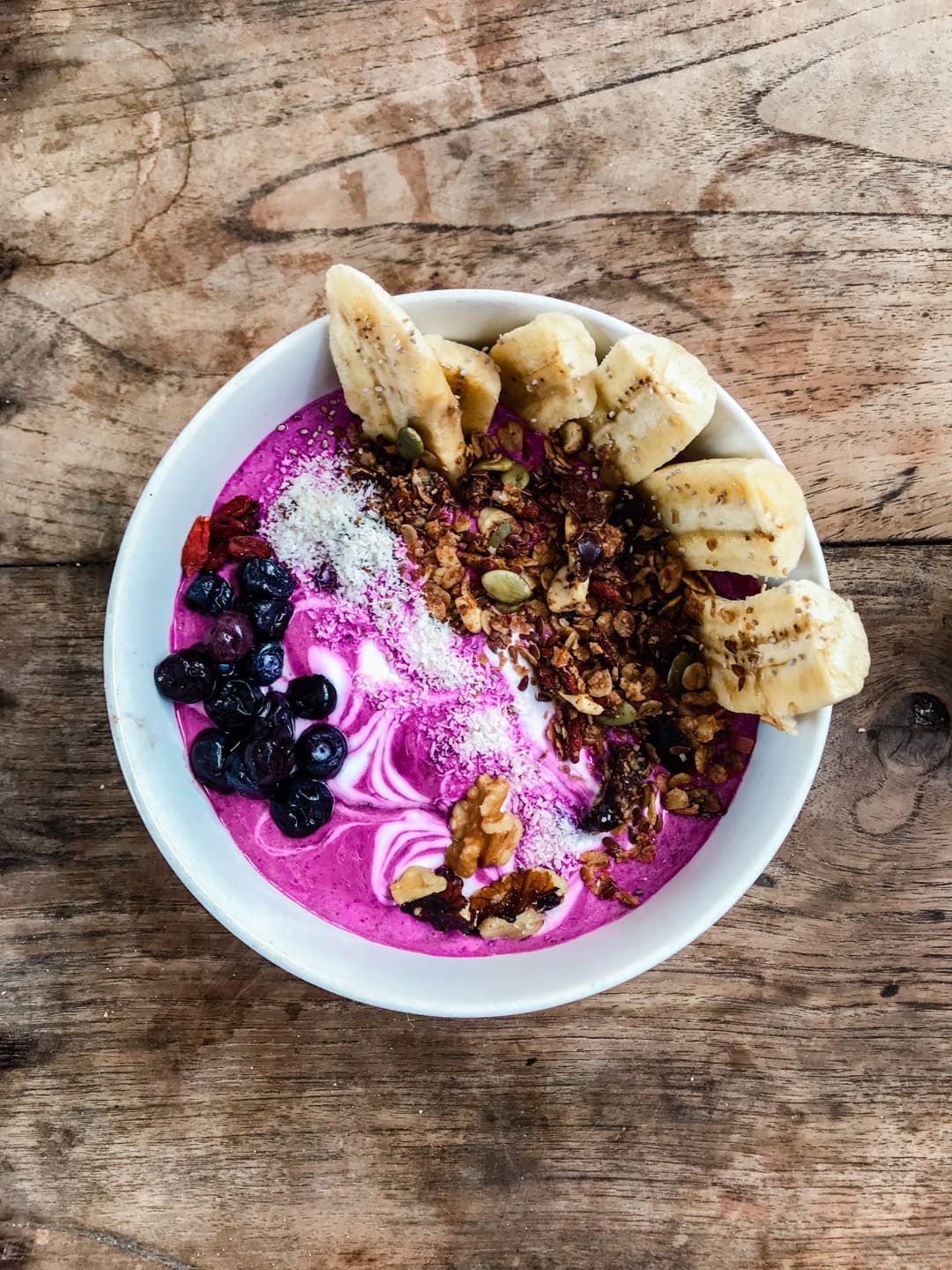 A pink smoothie bowl made from dragonfruit and coconut and topped with fruit, nuts and seeds known as the Pink Panther from Ginger and Jamu in Lembongan, Bali.