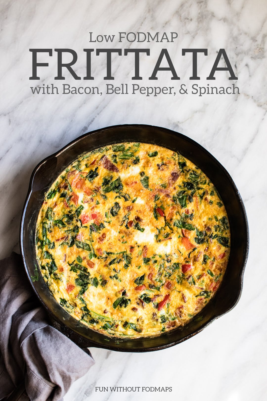 A cast iron skillet filled with frittata sits on a white marble background. Dark gray text reads "Low FODMAP Frittata with Bacon, Bell Pepper, & Spinach"