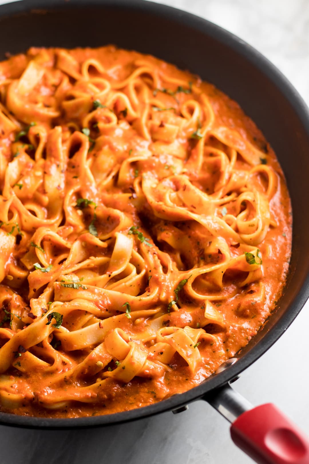 Fettuccine swimming in a roasted red pepper sauce and topped with finely sliced fresh basil.