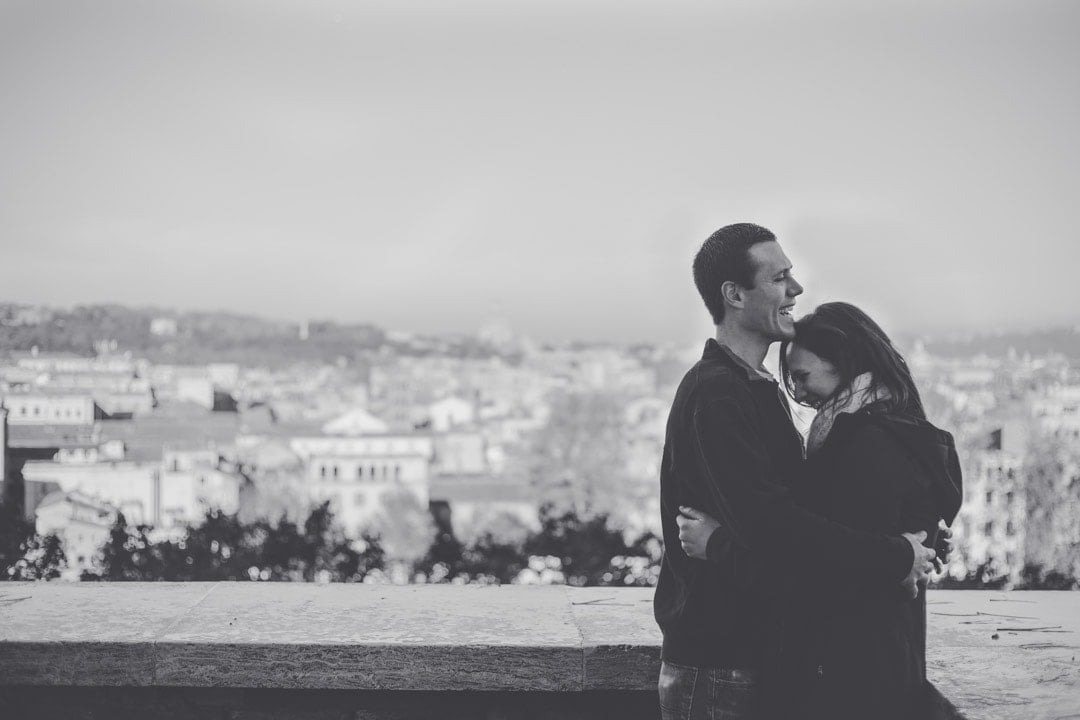 A couple laughing with Rome, Italy in the background