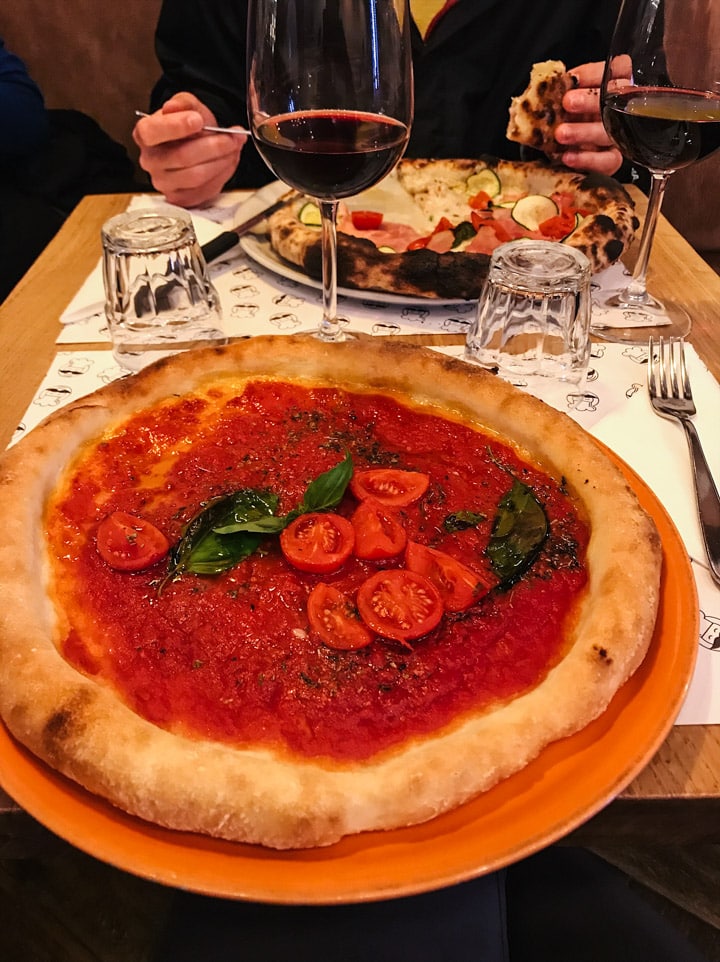 A large gluten free pizza topped with tomato sauce at Mister Pizza in Florence Italy 
