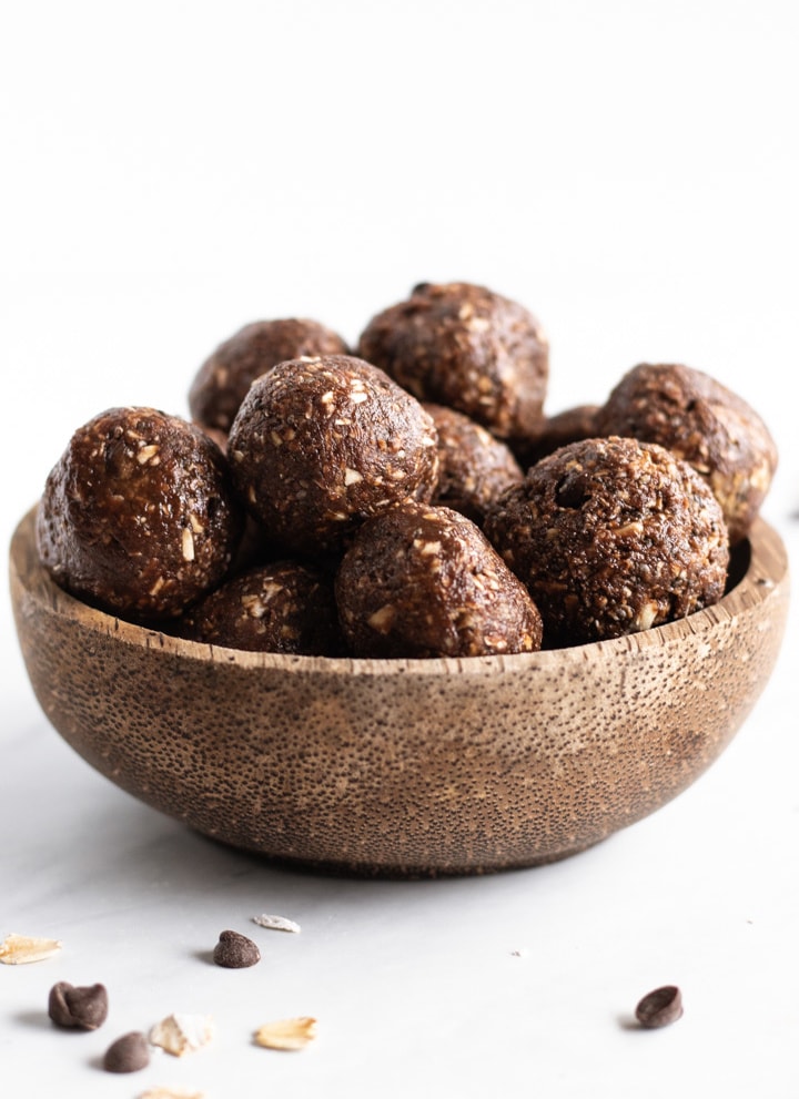 A coconut shell bowl filled with little energy balls aka low FODMAP peanut butter brownie bites.
