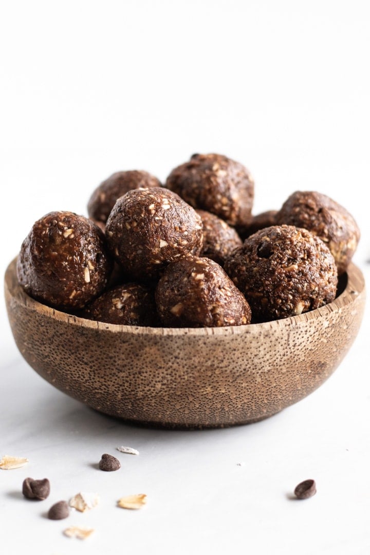 A coconut shell bowl filled with small chocolate energy balls
