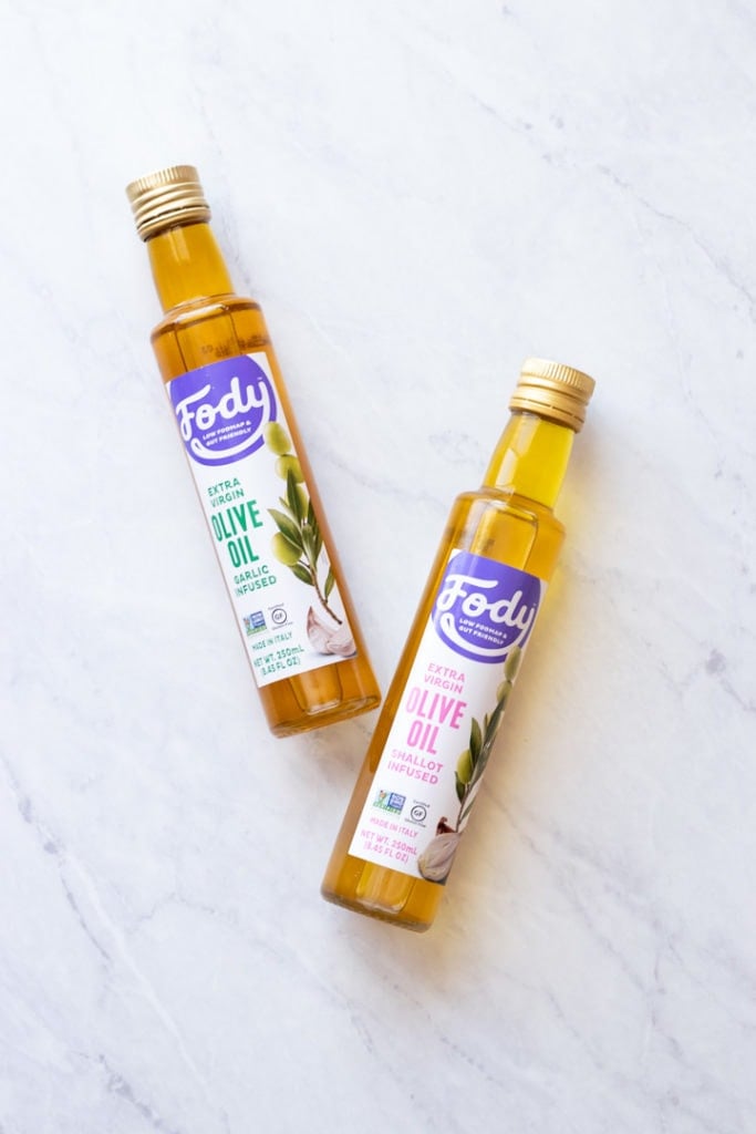 FODY Foods garlic-infused olive oil and shallot-infused olive oil on a white marble background