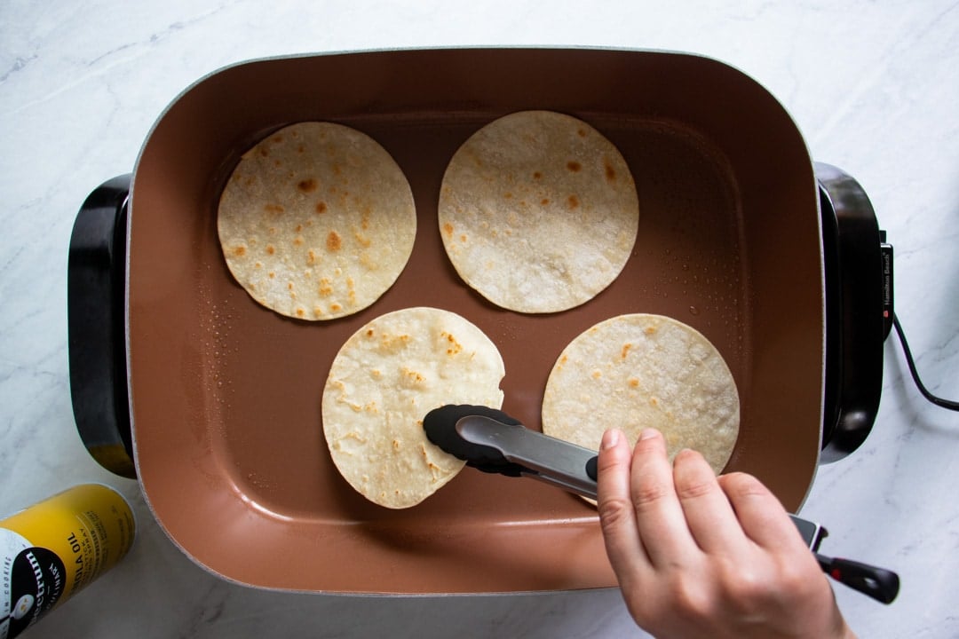 Skillet with corn tortillas browning