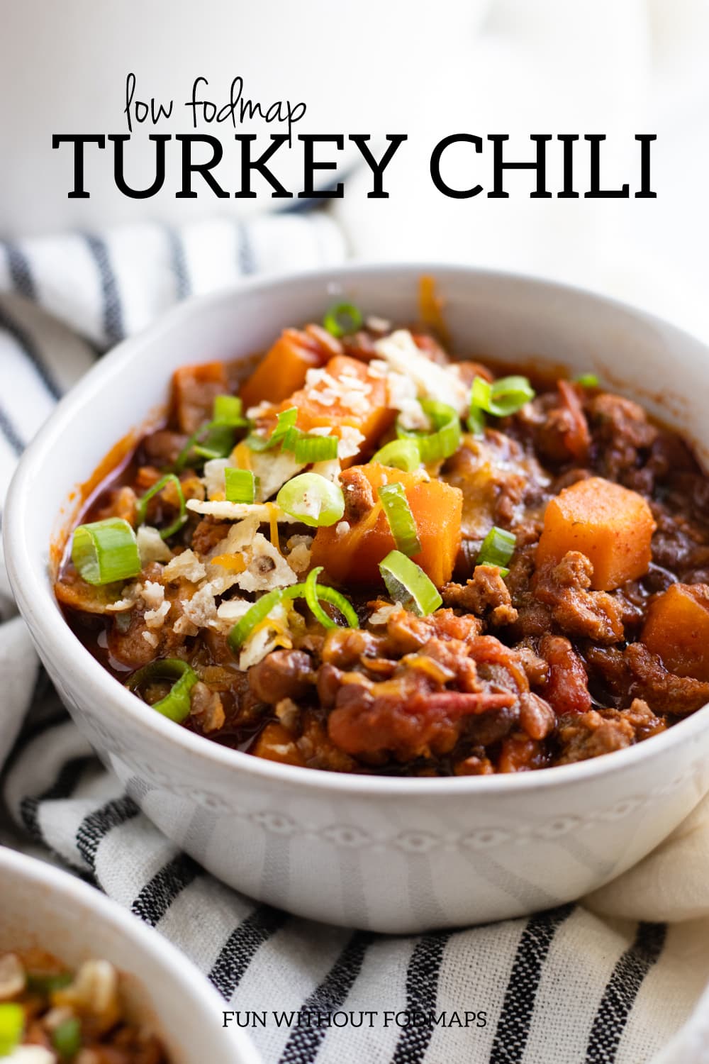 A close up of a bowl of turkey chili made with sweet potatoes and canned lentils. Above the bowl, a black text overlay reads "Low FODMAP Turkey Chili."