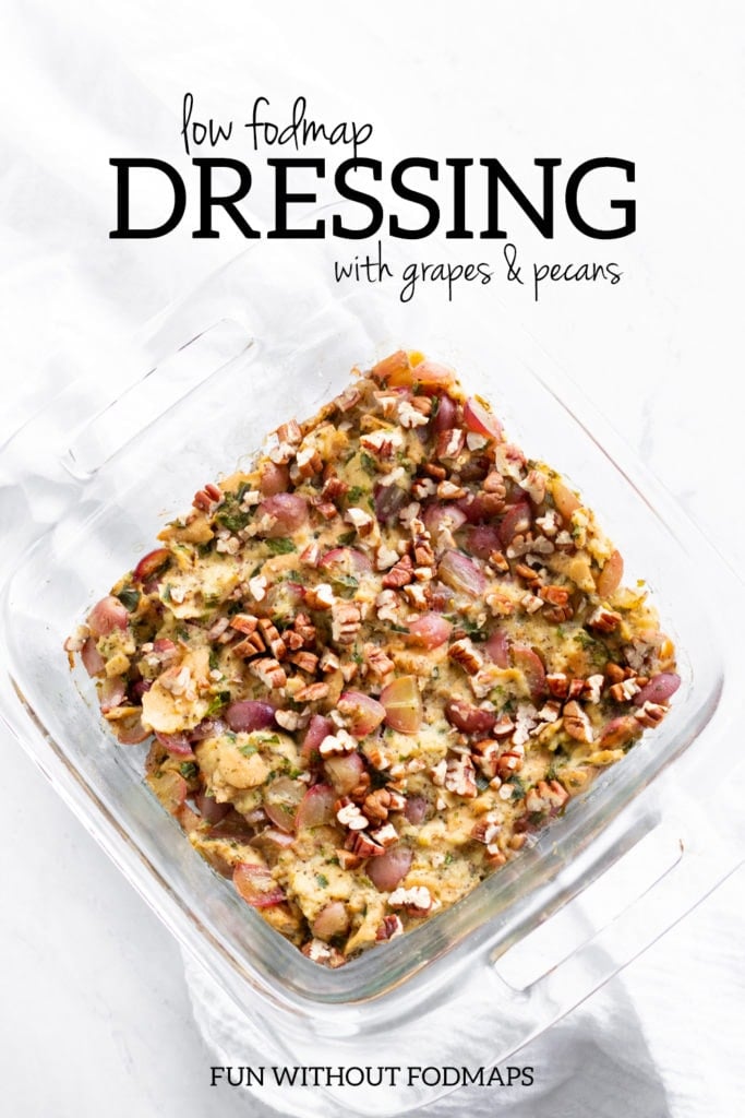 Looking down at a baking dish filled with stuffing. Above, a black text overlay reads "low FODMAP dressing with grapes and pecans."