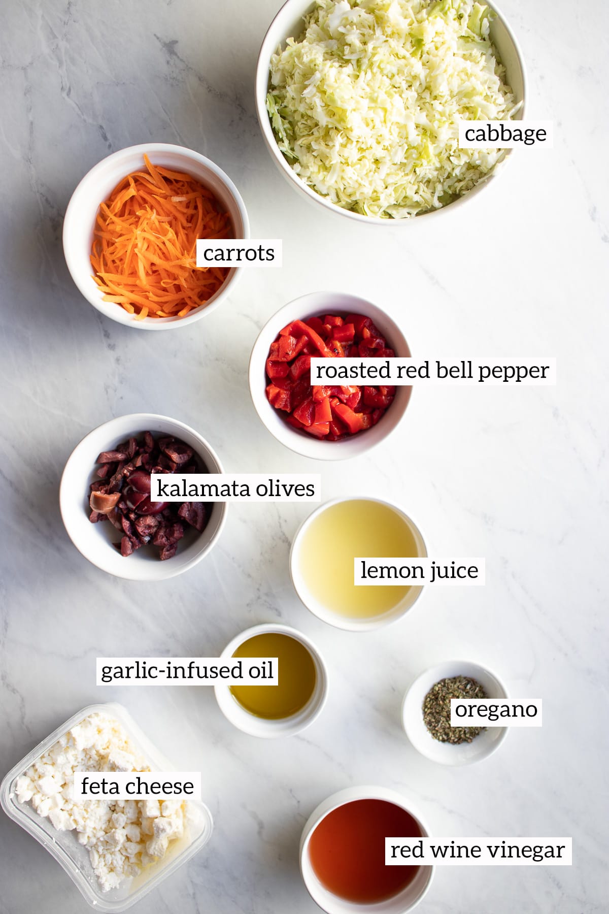 Ingredients needed for this coleslaw recipe have been measured out and placed in small white bowls.