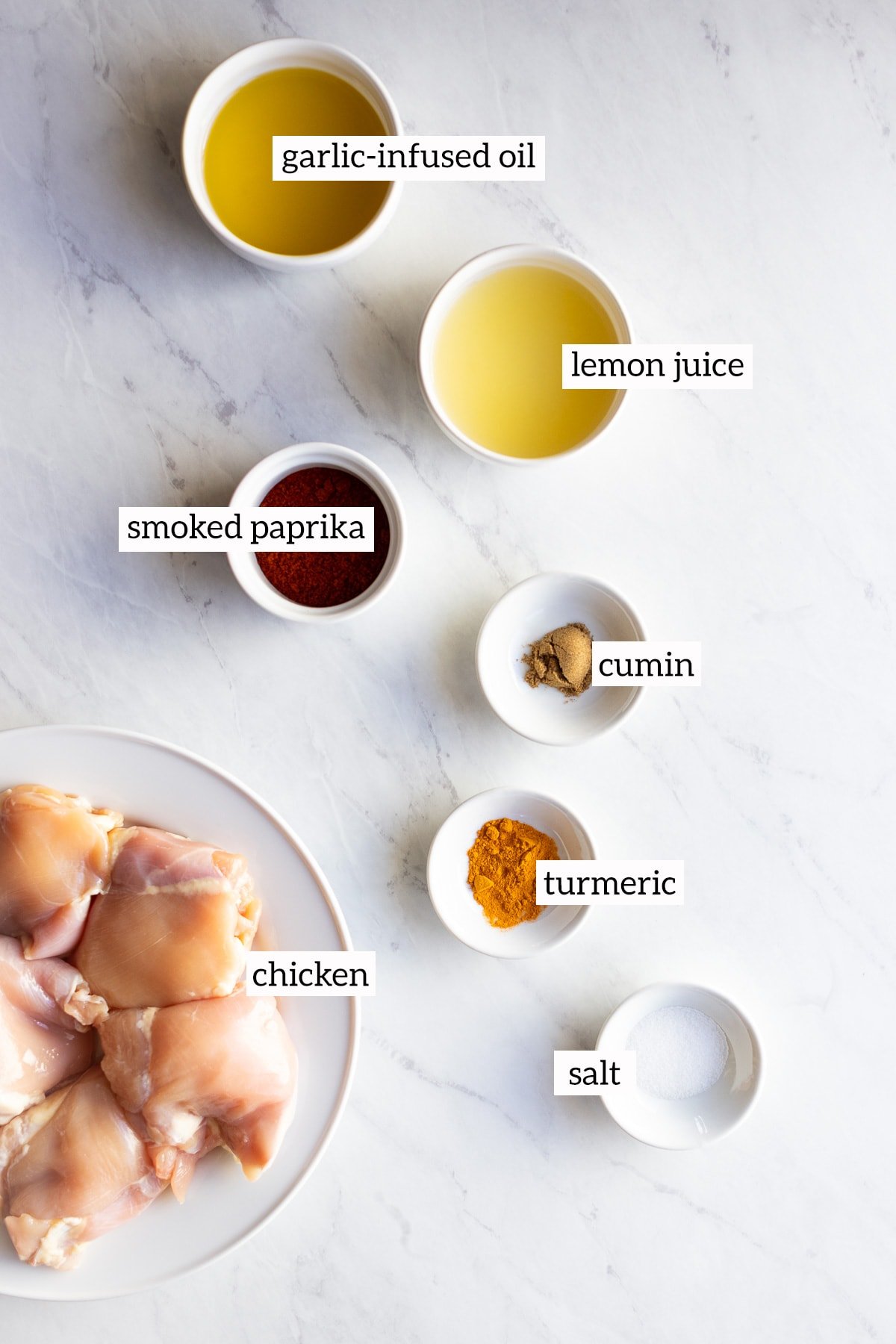 Ingredients needed for lemon spiced chicken are measured out into individual dishes.