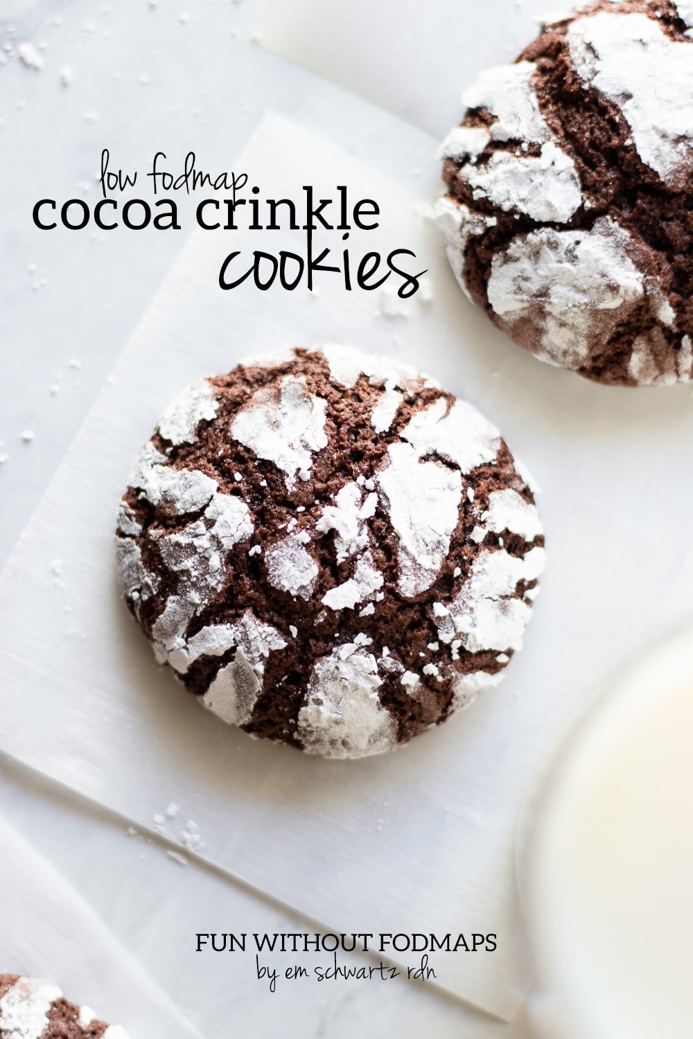 baked cocoa crinkle cookies on parchment paper squares a black text overlay reads low FODMAP cocoa crinkle cookies