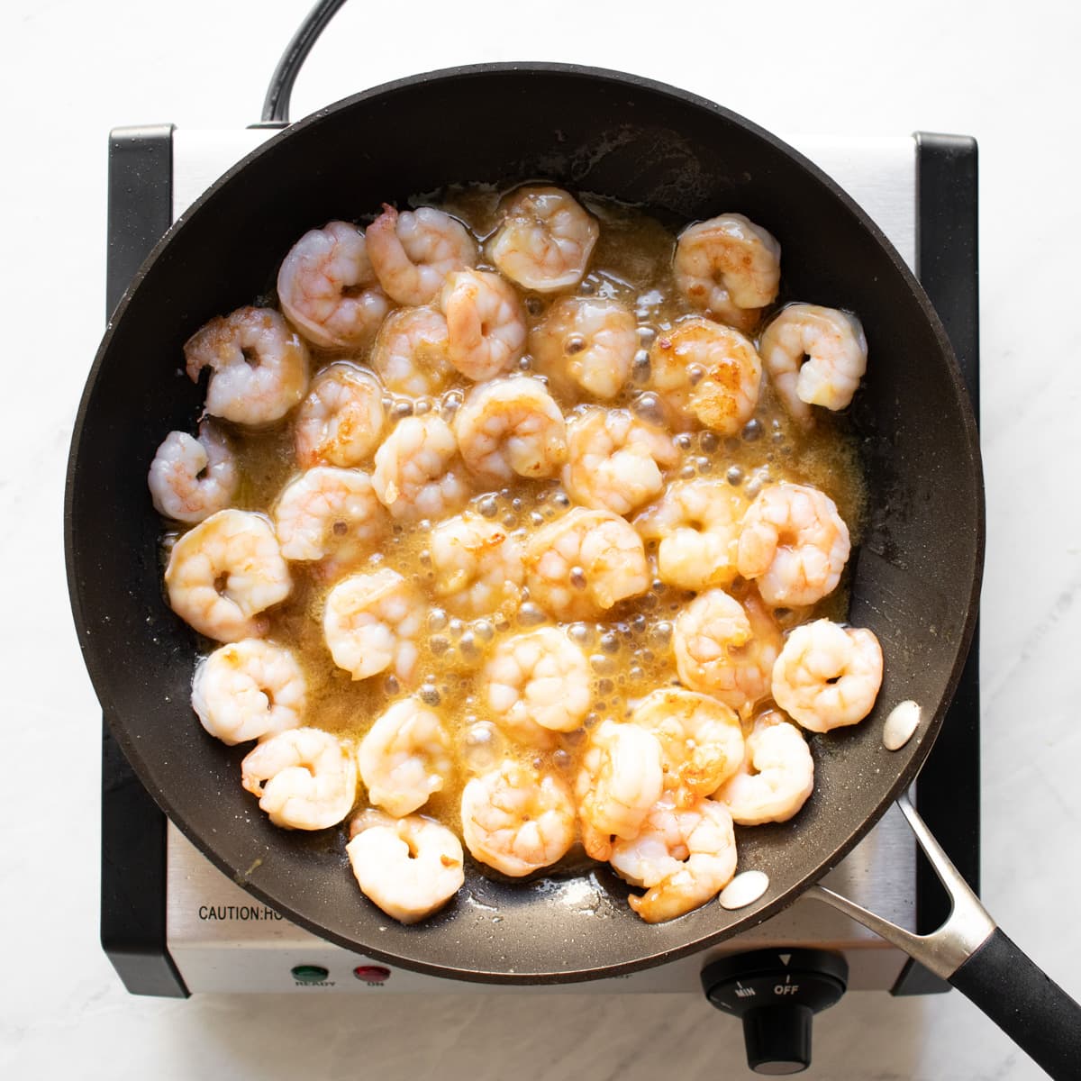 Maple-dijon mustard sauce bubbling with cooked shrimp.