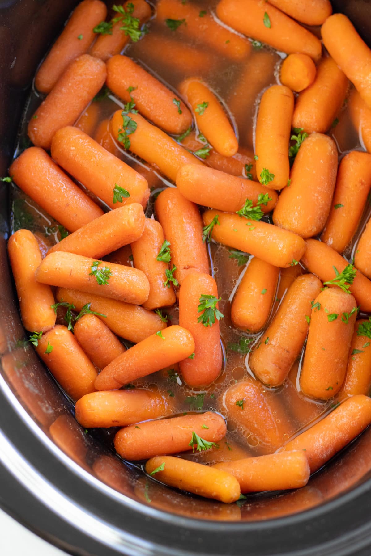 Cooked low FODMAP maple-infused carrots in a slow cooker.