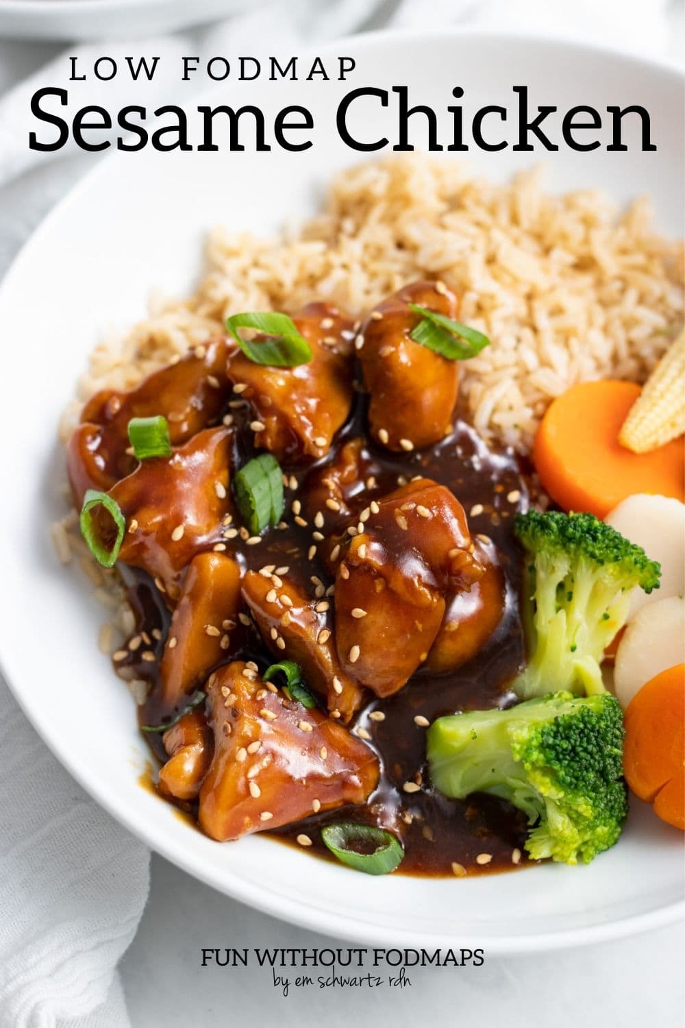 A bowl of low FODMAP sesame chicken, steamed mixed veggies, and brown rice. A black text overlay above it reads "Low FODMAP Sesame Chicken."