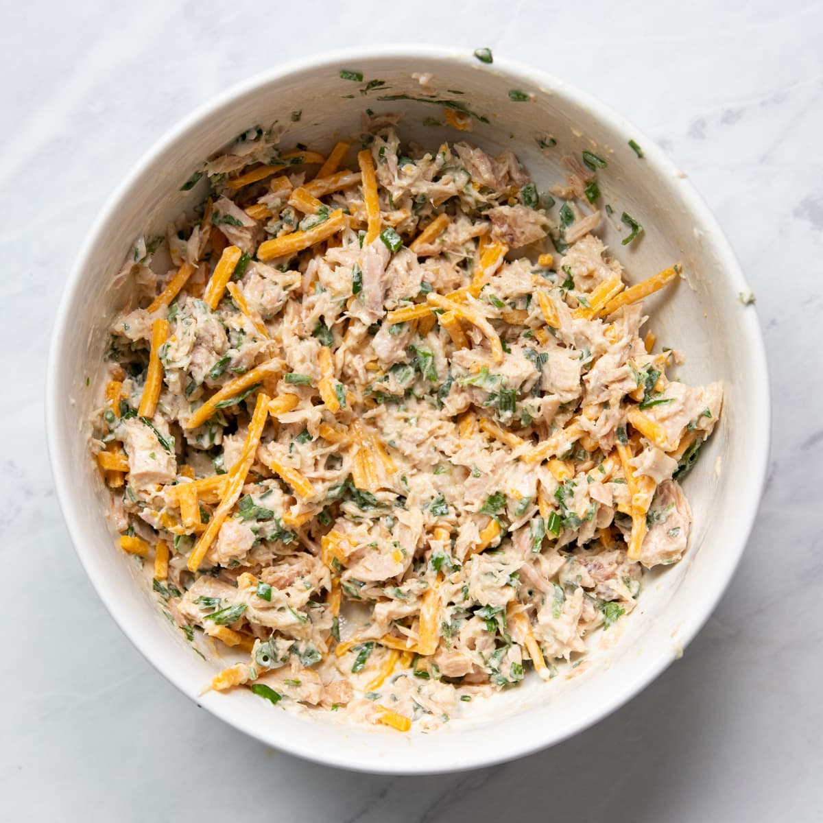 Canned tuna salad with cheddar cheese in a bowl