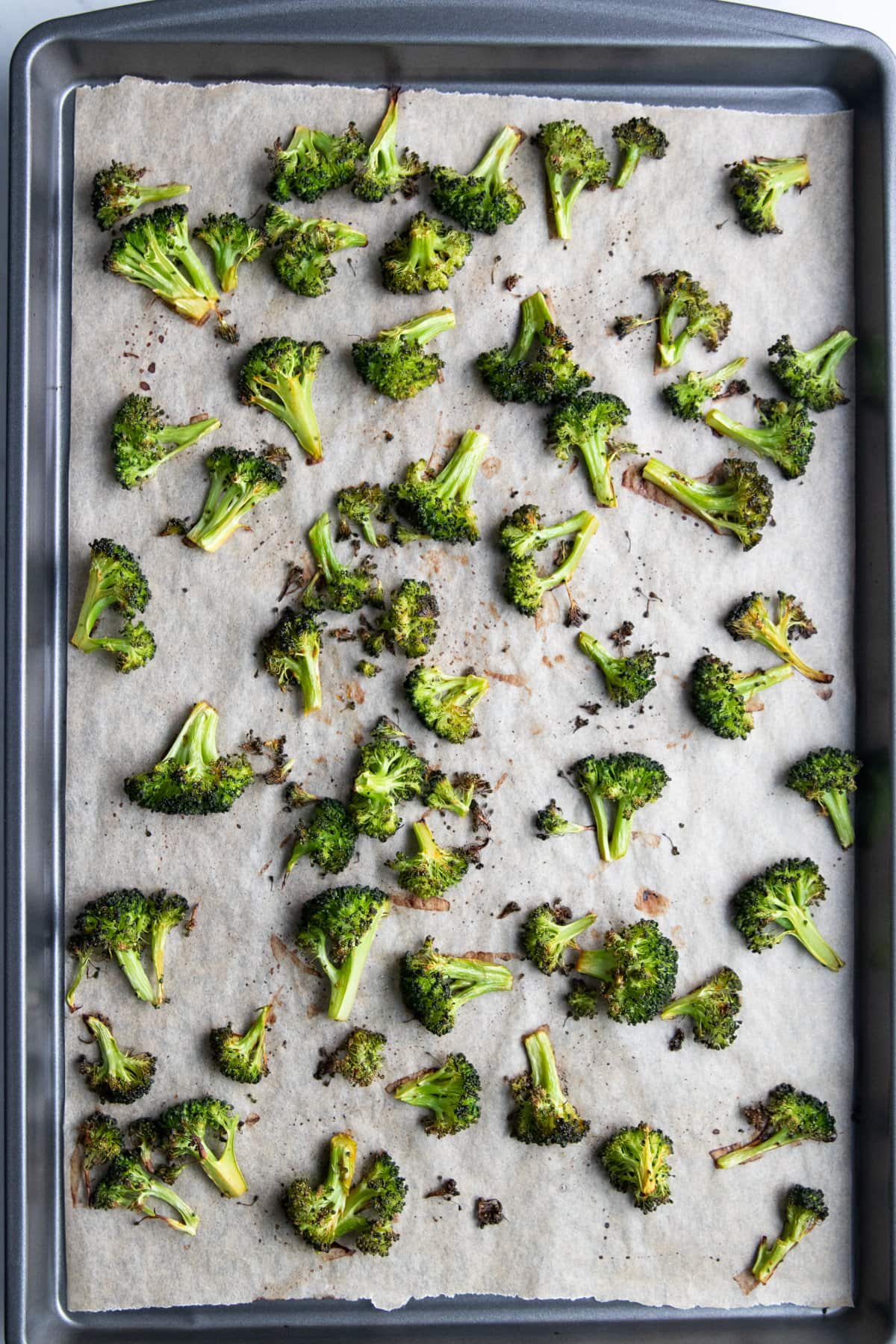 A baking sheet with roasted broccoli florets.